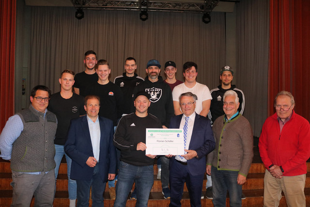 Übergabe der Urkunde im Saal der Sommerau. Auf dem Bild vorne von links: 1. Vorsitzender TSV Buchenberg Marc Murschhauser, 1. Bürgermeister Marktgemeinde Buchenberg Toni Barth, DFB Club-100-Mitglied 2019 Florian Schäfer, Bezirksehrenamtsbeauftragter des Bayerischen Fußballverbandes Günther Brenner, Singer Georg und Werner Sponsel, beide Ehrenvorsitzende des TSV Buchenberg; dahinter: einige Fußballer des TSV Buchenberg mit Trainer Ralph Maier