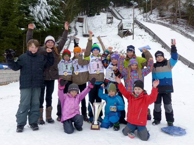 Das Buchenberger Springerteam freut sich über den gewonnenen Wanderpokal (im Hintergrund die K15- und K30-Schanze)