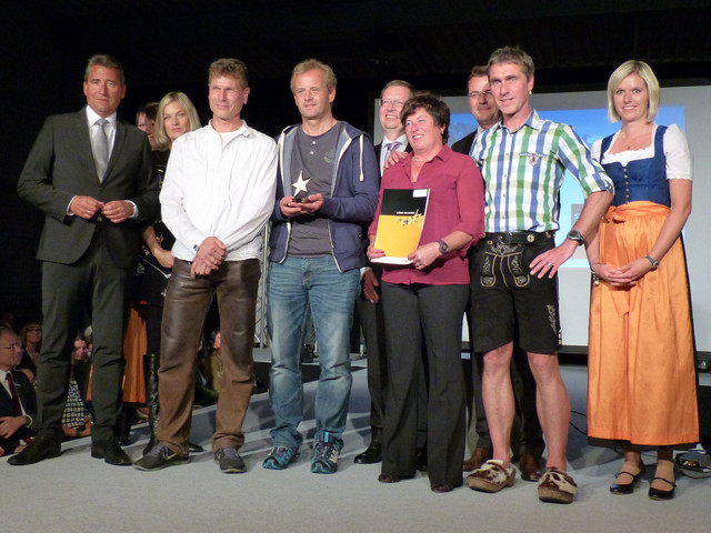 Die glücklichen Gewinner aus Buchenberg bei der Preisverleihung in Sonthofen (von links nach rechts): Rainer Schaidnagel (Raiffeisenbank-Vorstand), Kati Schneider (ehemalige Eiskunstläuferin), Christoph Mach, Christian Rimmel, (beide Skisprung-Trainer), Heinrich Beerenwinkel (Raiffeisenbank-Vorstandssprecher), Conny Klarin (Skisprung-Abteilungsleiterin), Wilhelm Oberhofer (Raiffeisenbank-Vorstandsmiglied), Steffen Wiedemann (Skisprung-Trainer), umrahmt von Repräsentantinnen der Raiffeisenbank